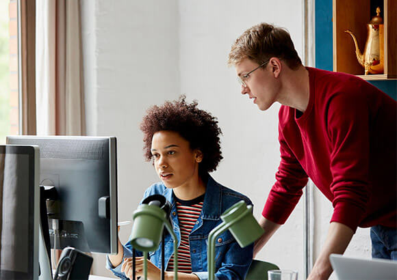 stock image of two people looking at a computer screen