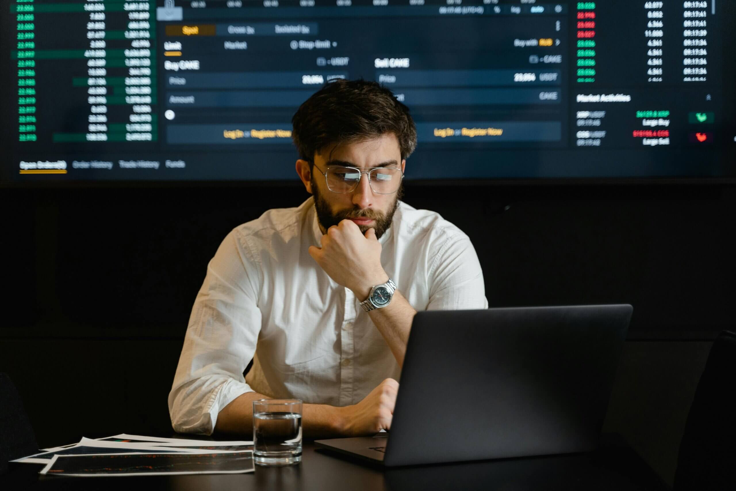 A man sitting at a desk using a laptop.